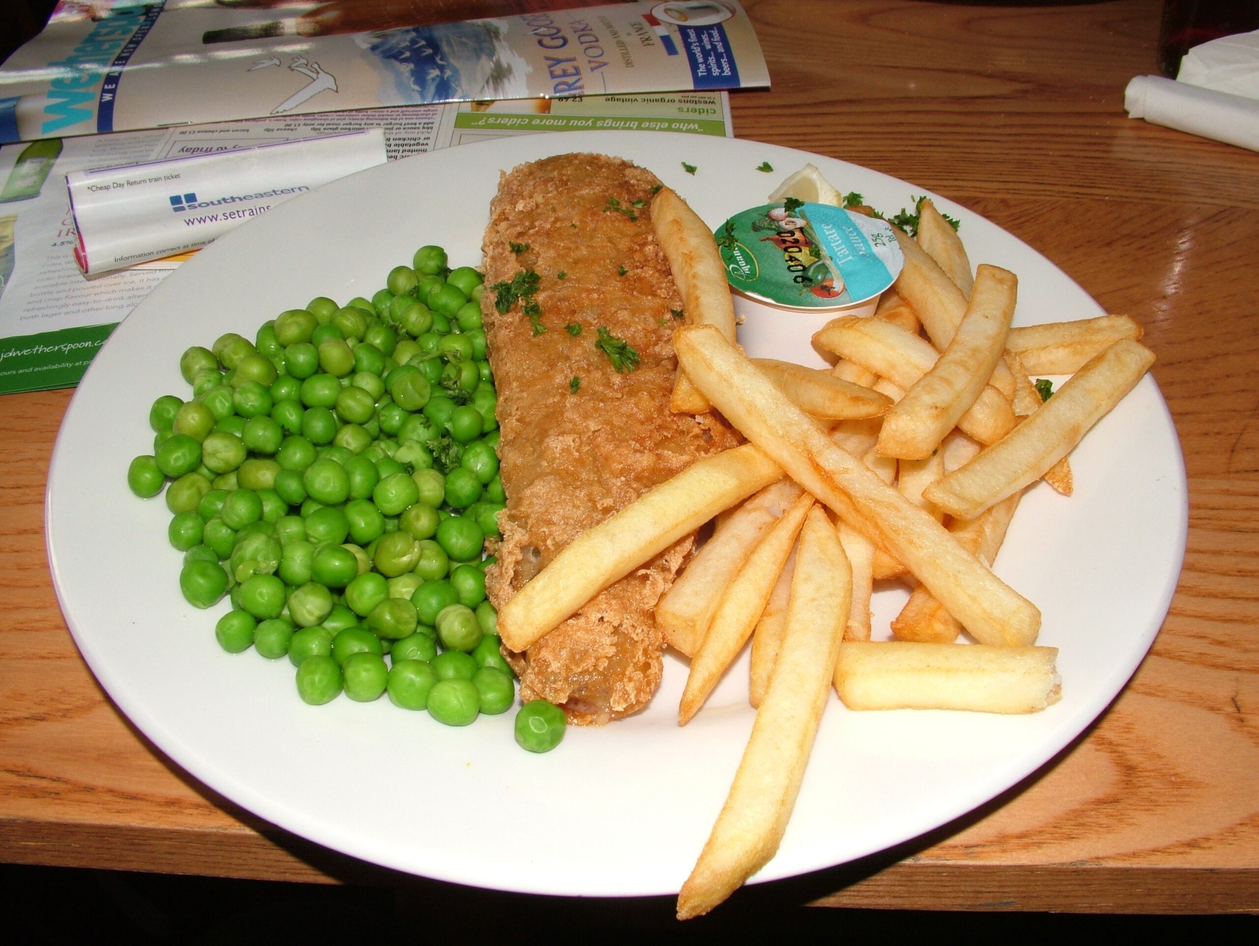 Crispy battered fish with thick-cut chips and peas