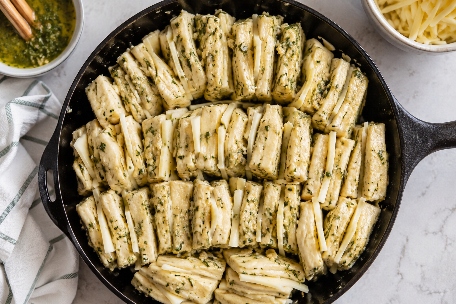 Garlic butter dough pieces arranged upright in a skillet