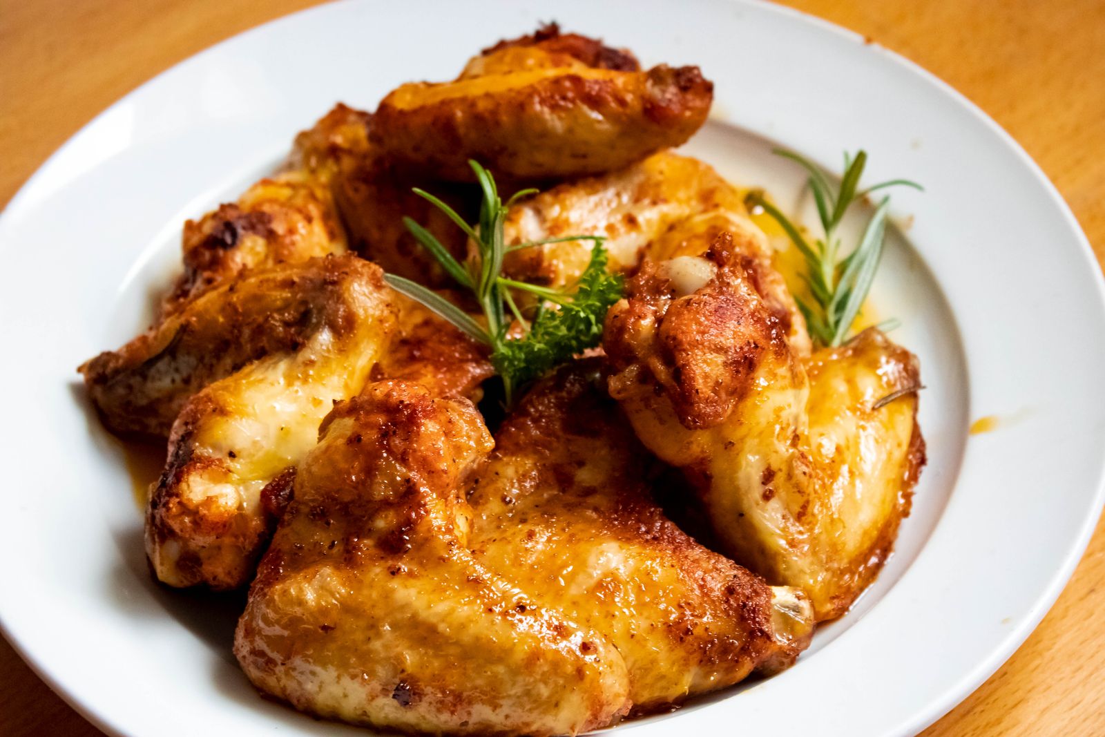 Golden-brown chicken wings garnished with fresh herbs