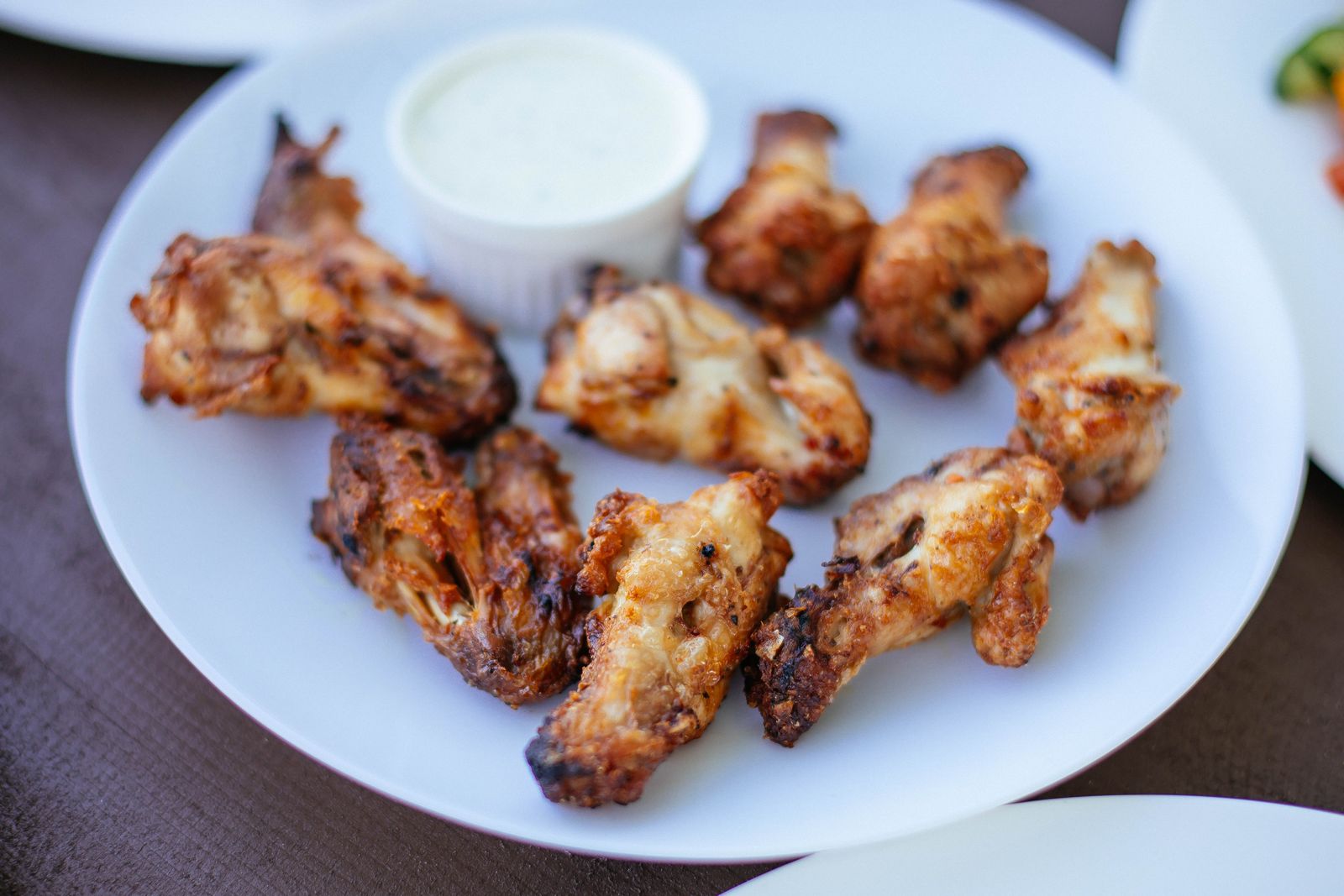 Delicious crispy chicken wings served on a white plate with dipping sauce