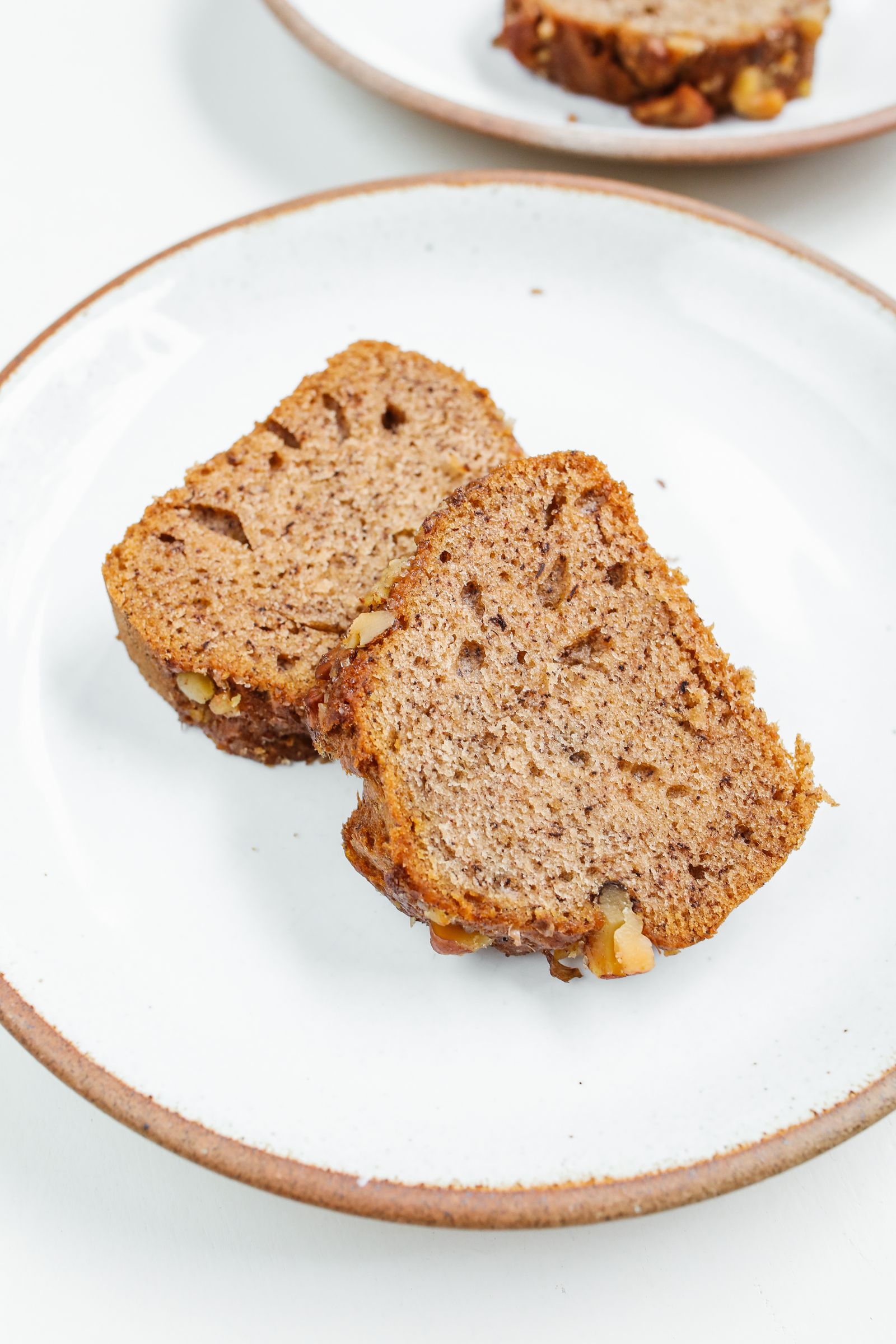 Fresh banana bread slices on a white ceramic plate