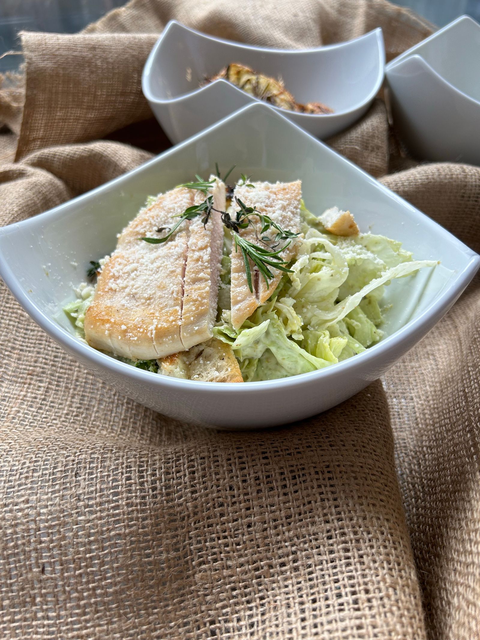 Close-up of a Caesar salad with grilled chicken in a stylish bowl