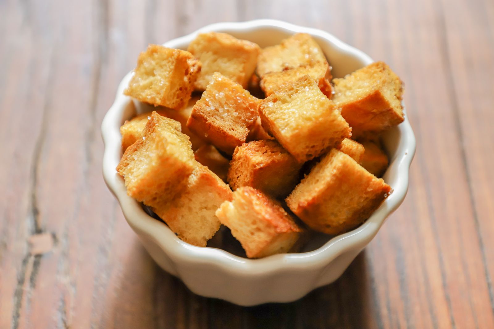 Close-up of golden-brown croutons in a white ceramic bowl