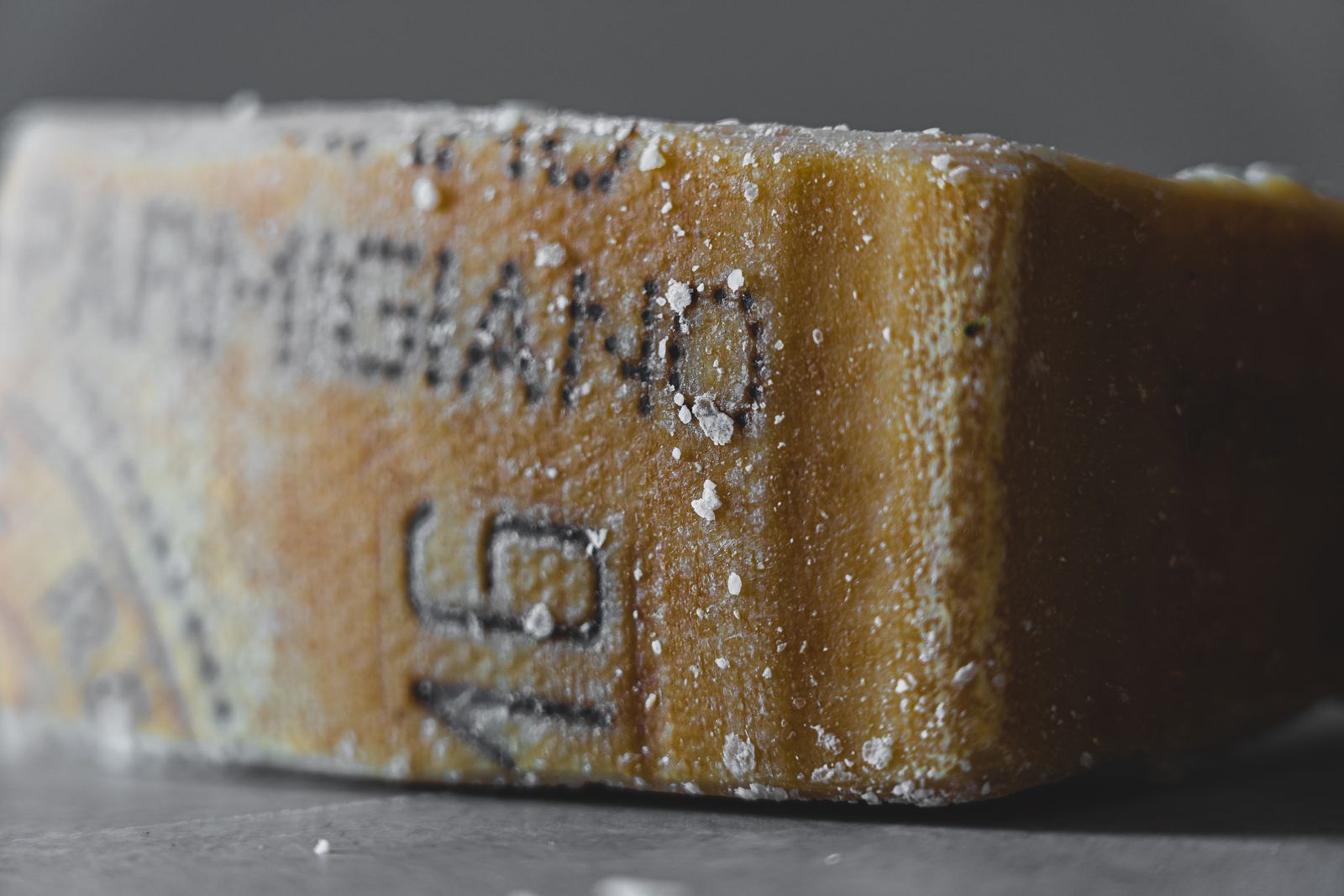 Detailed close-up of an aged Parmigiano cheese block