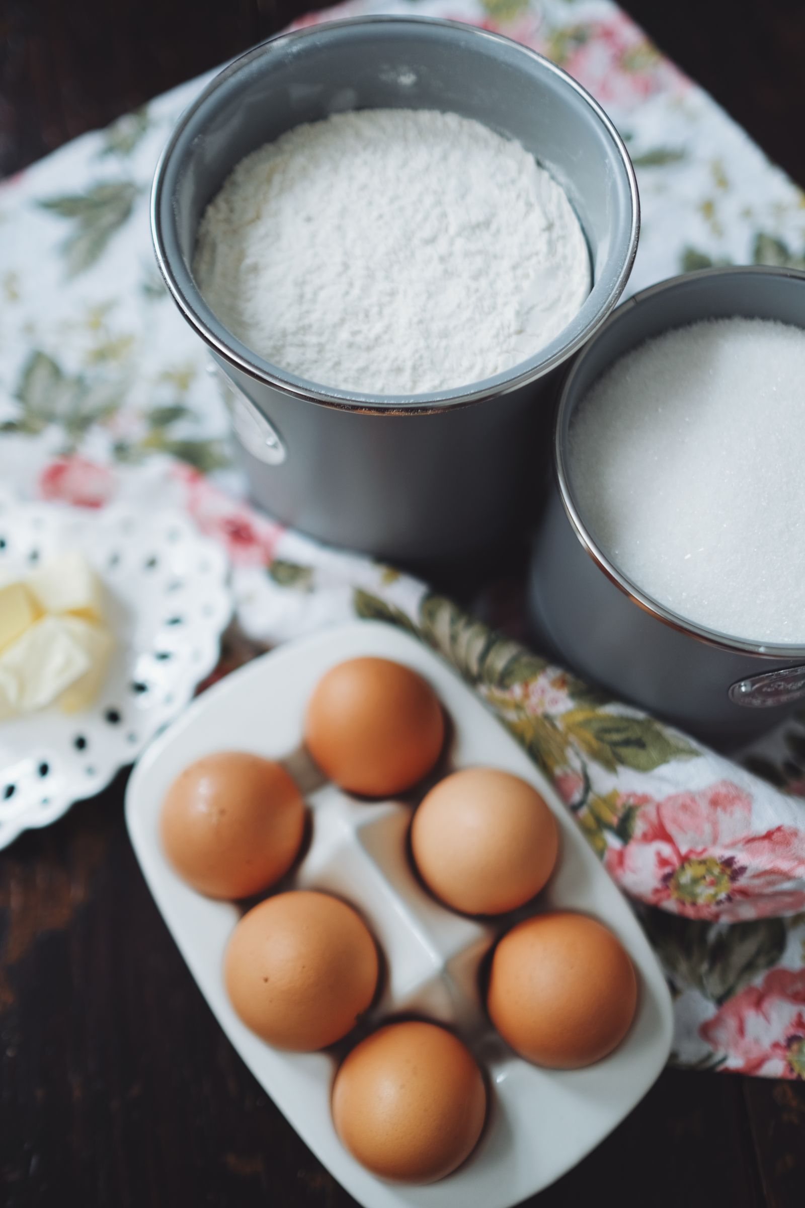 Baking ingredients including eggs, flour, sugar and butter laid out before mixing