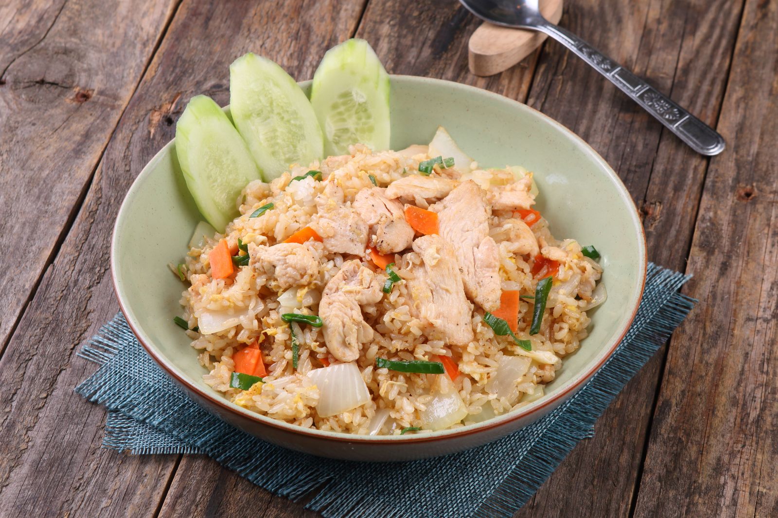 Mouthwatering chicken fried rice with fresh vegetables on a rustic wooden table