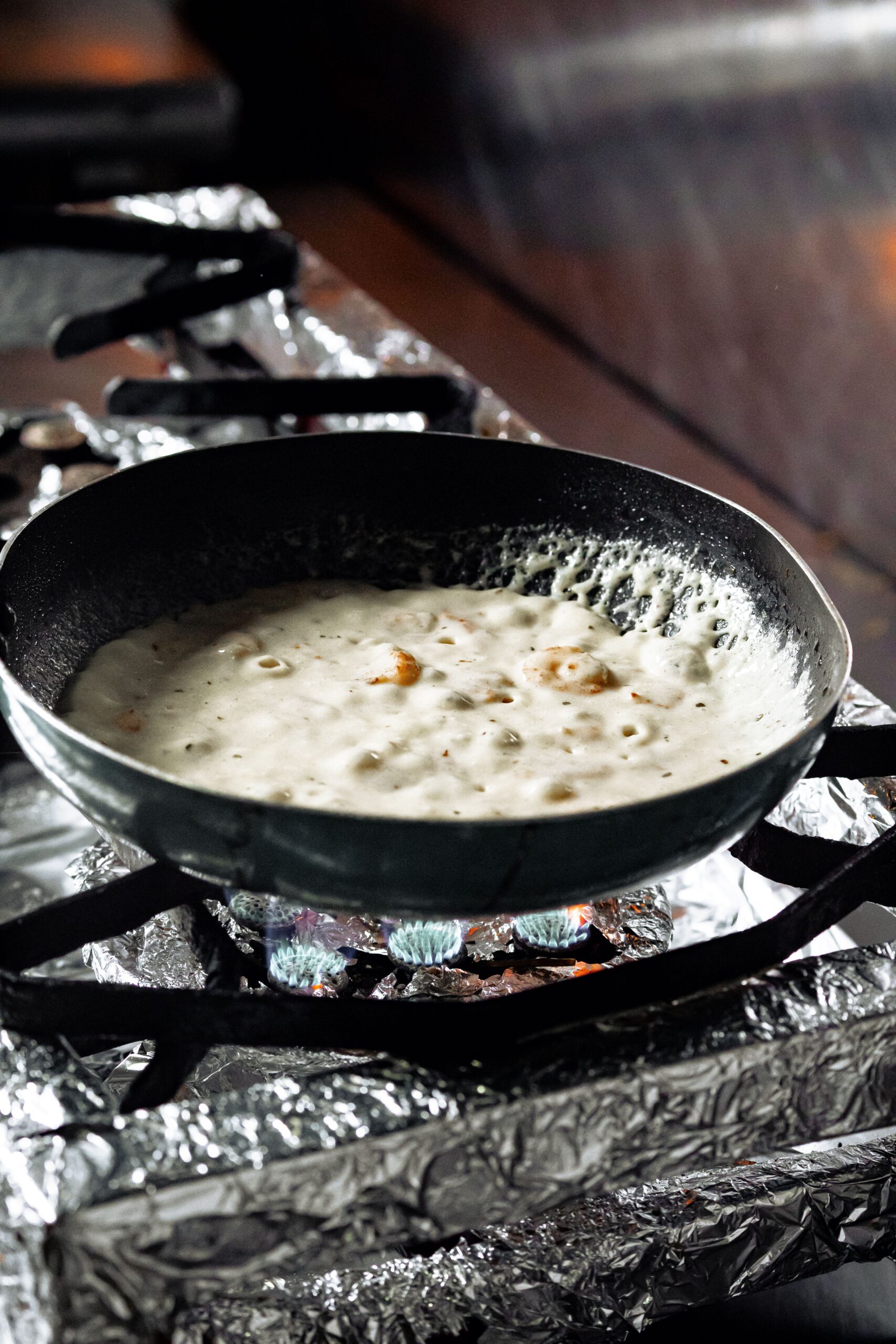 Creamy cheese sauce simmering in a pan for homemade mac and cheese
