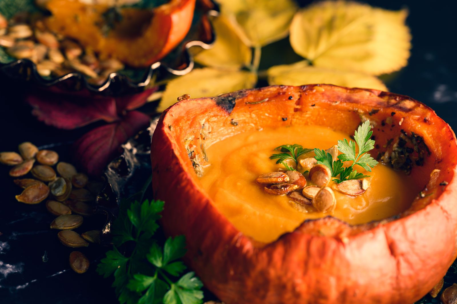 Creamy pumpkin soup served in a hollowed pumpkin bowl for a fall dinner