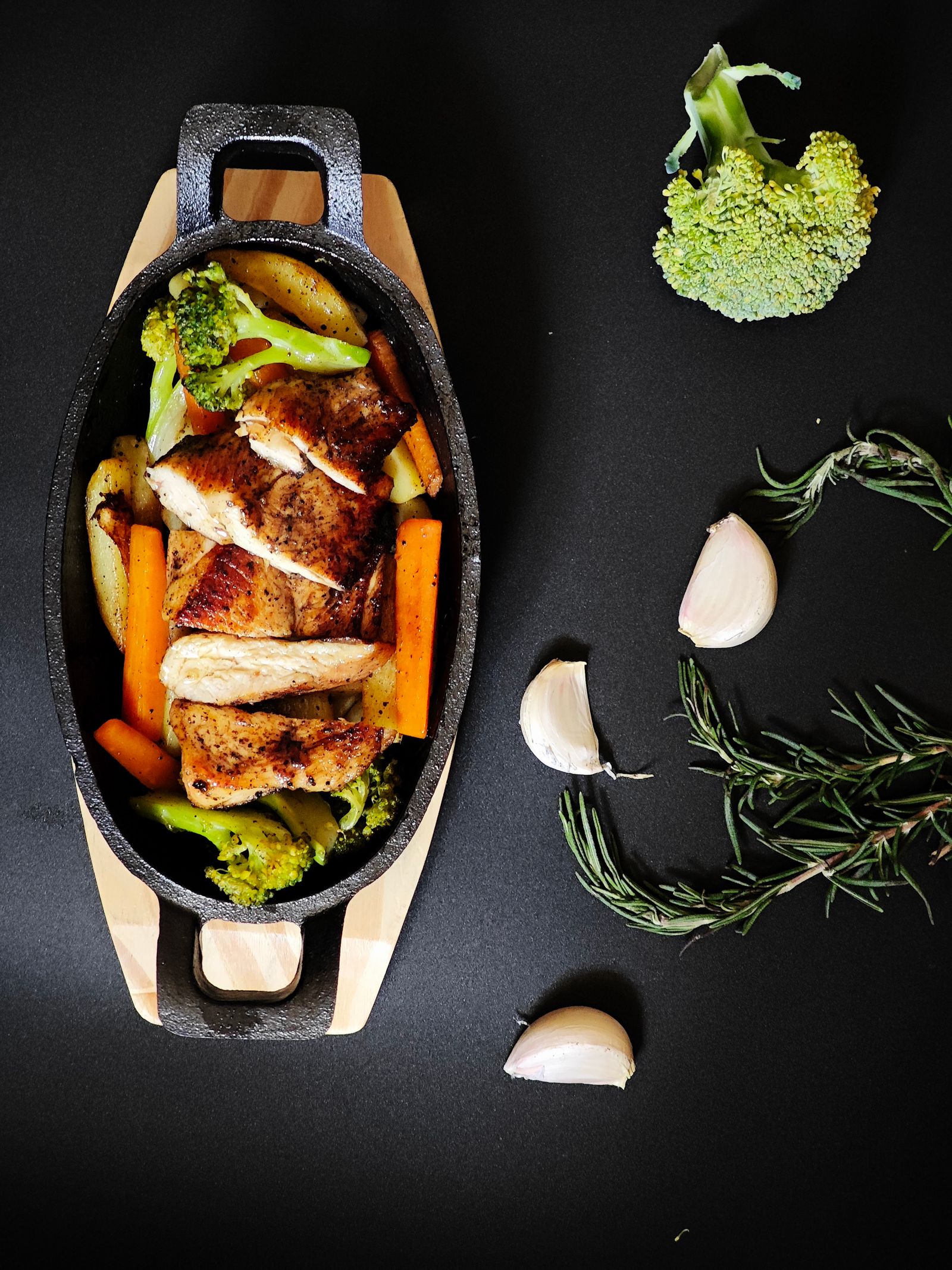 Overhead view of finished roasted chicken and vegetables in a pan, glazed and ready to serve