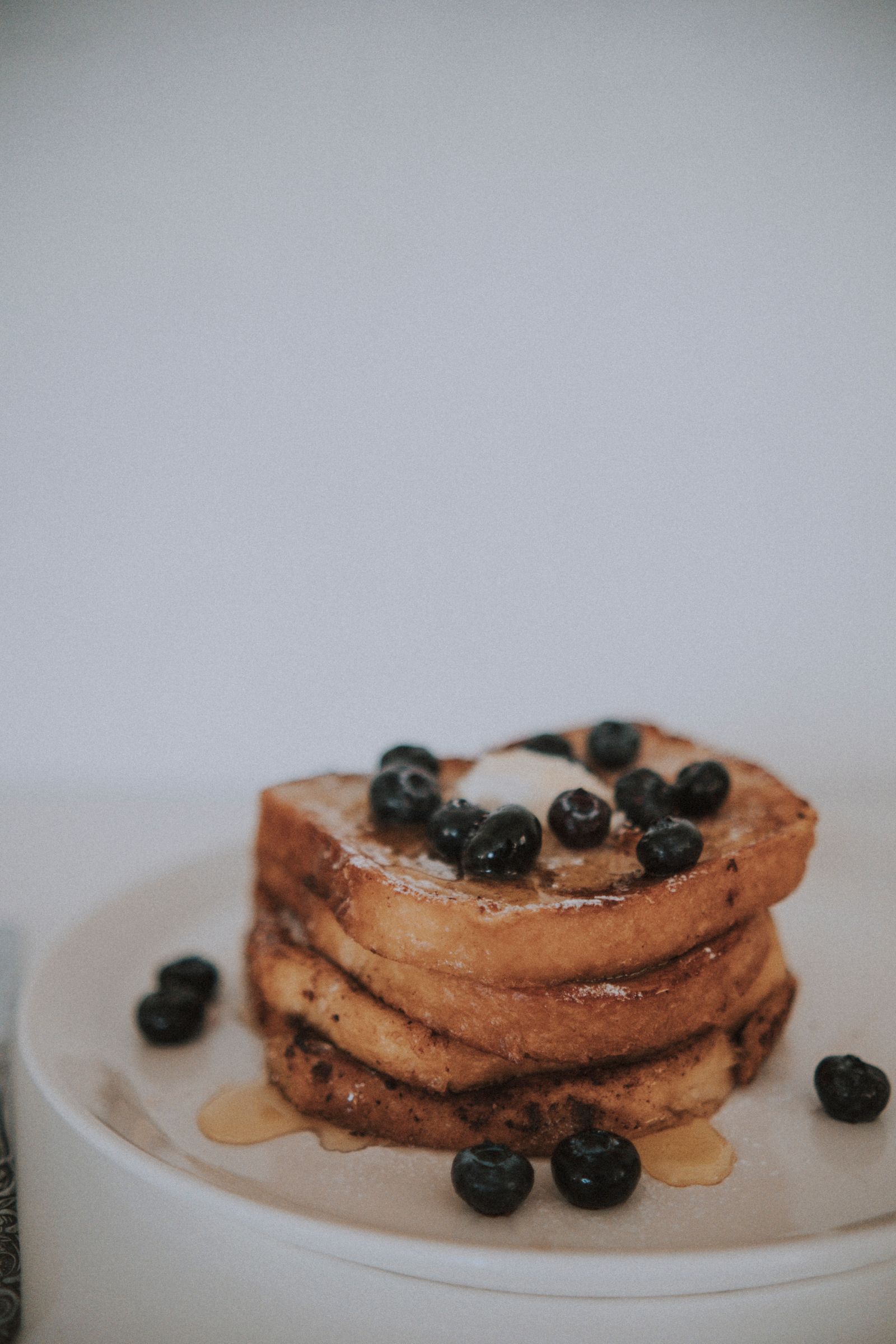 A mouthwatering stack of French toast topped with fresh blueberries and syrup