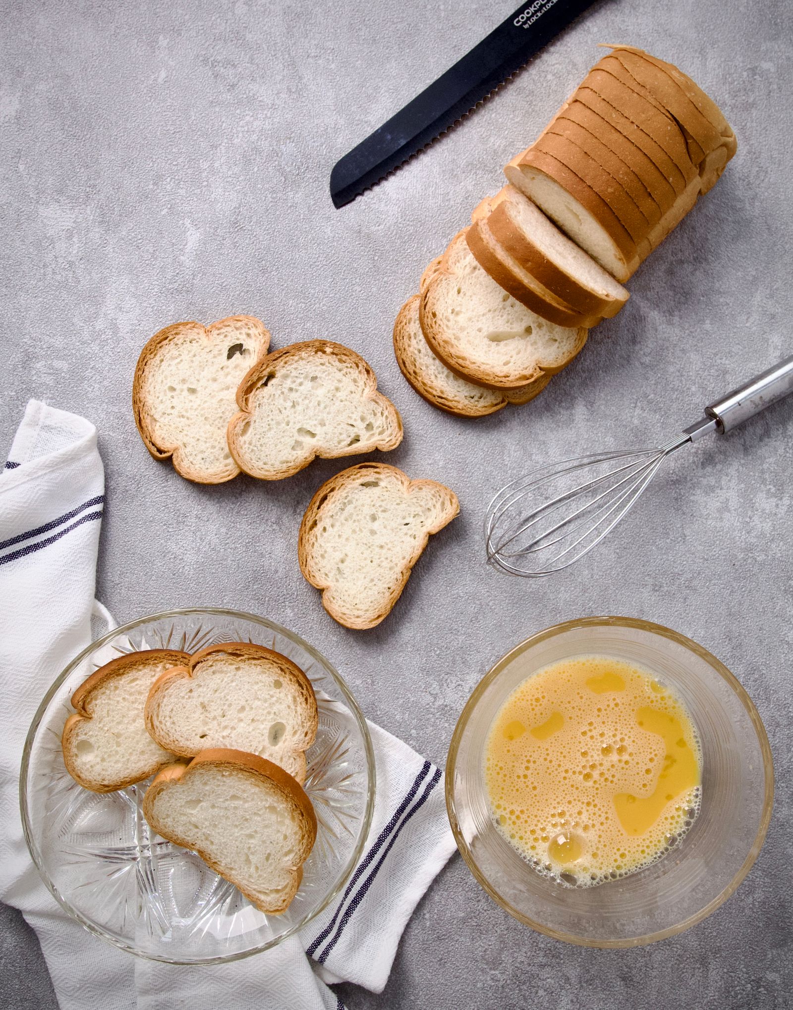 Overhead view of sliced bread and beaten eggs ready for cooking French toast
