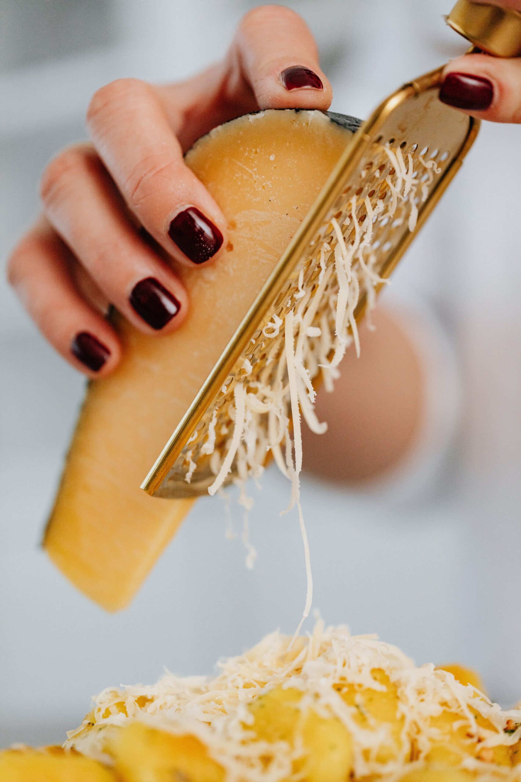 Hand grating cheese over macaroni for extra cheesy topping