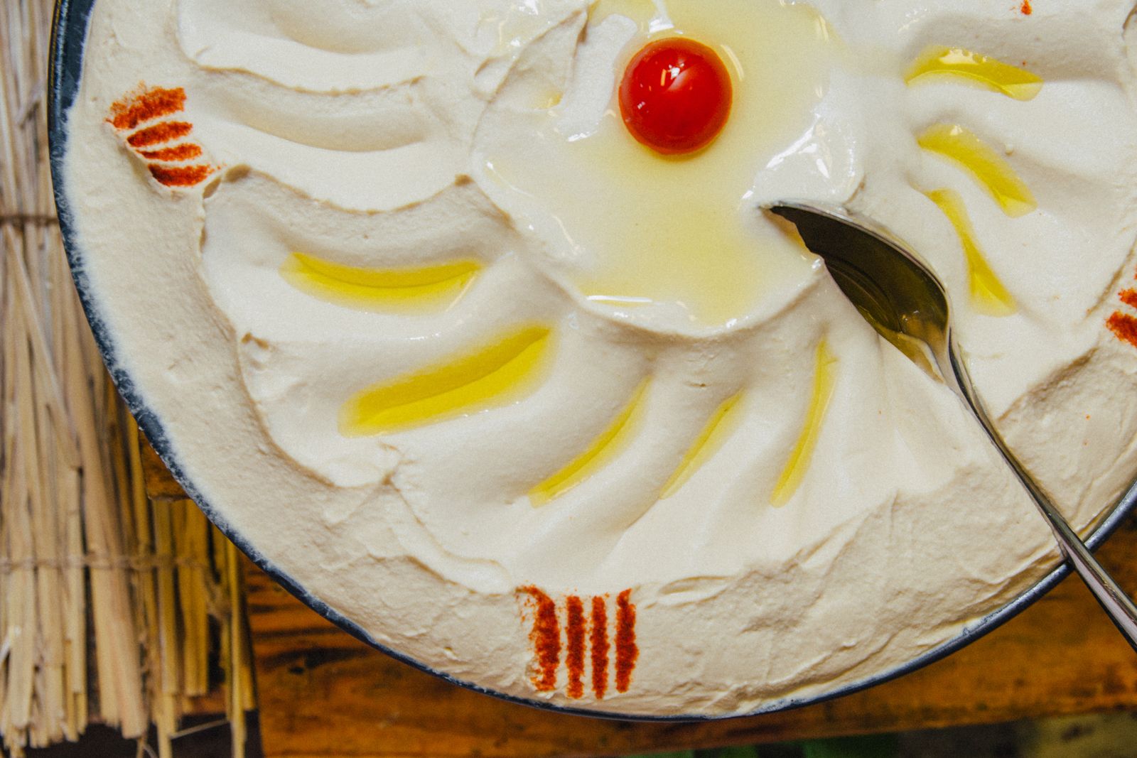 Top view of creamy hummus with olive oil garnish, served in a decorative dish