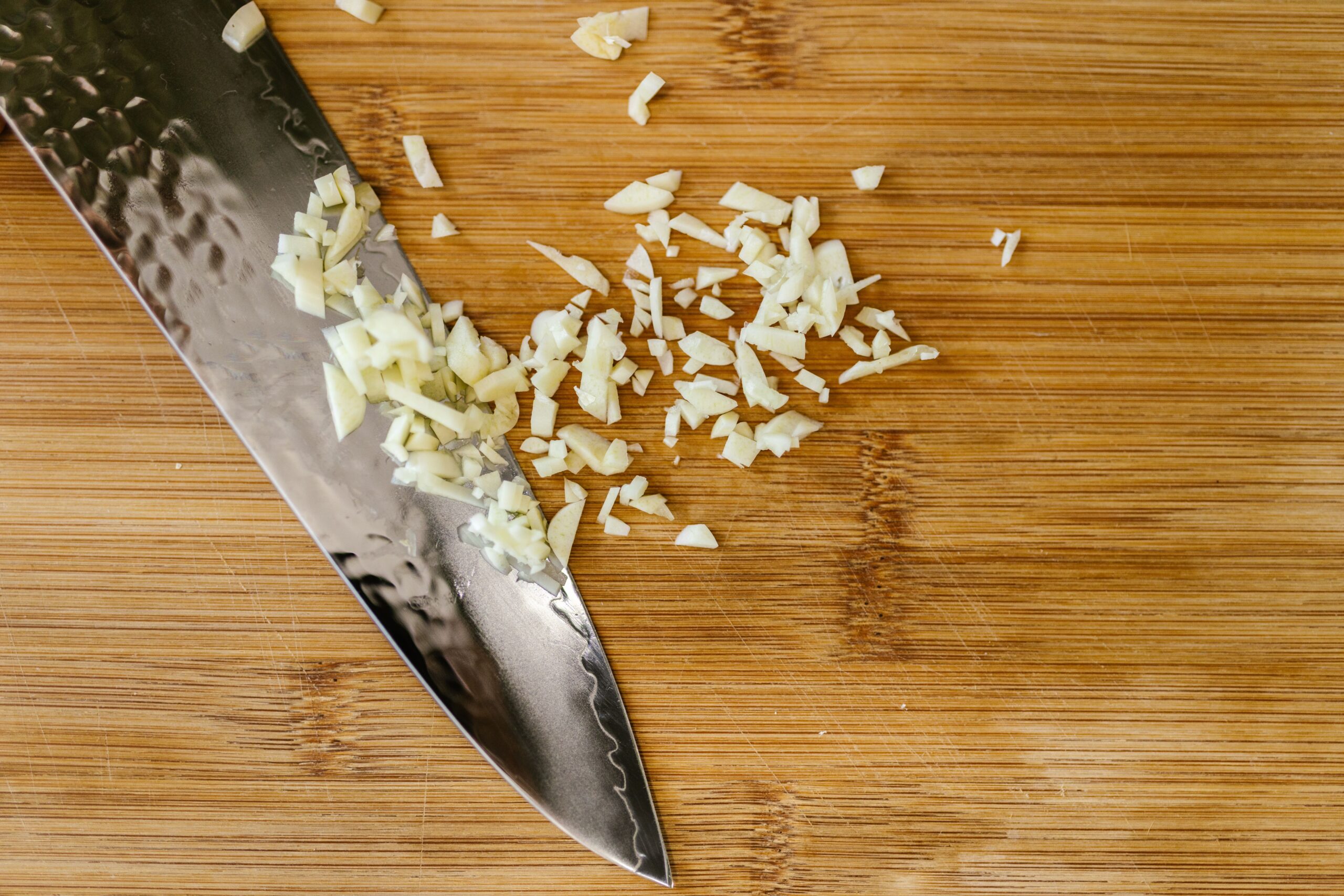 Minced garlic on a wooden cutting board