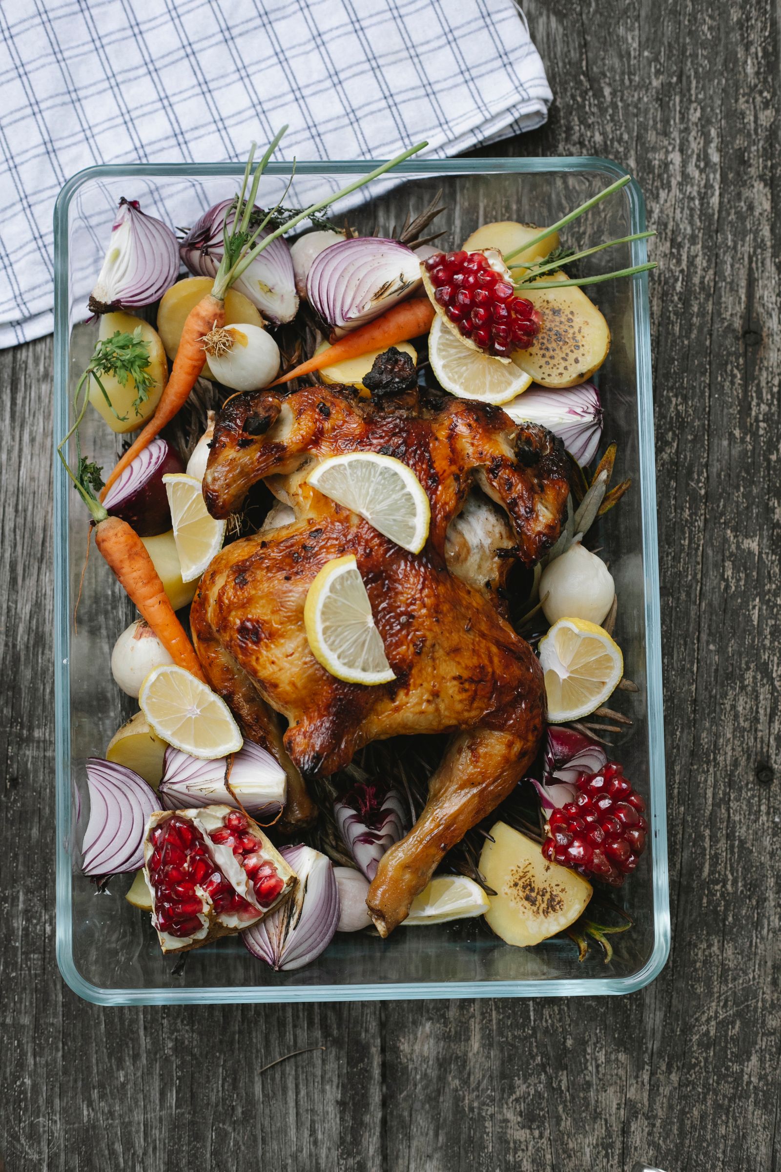 Overhead view of roasted chicken with potatoes and carrots in a baking dish