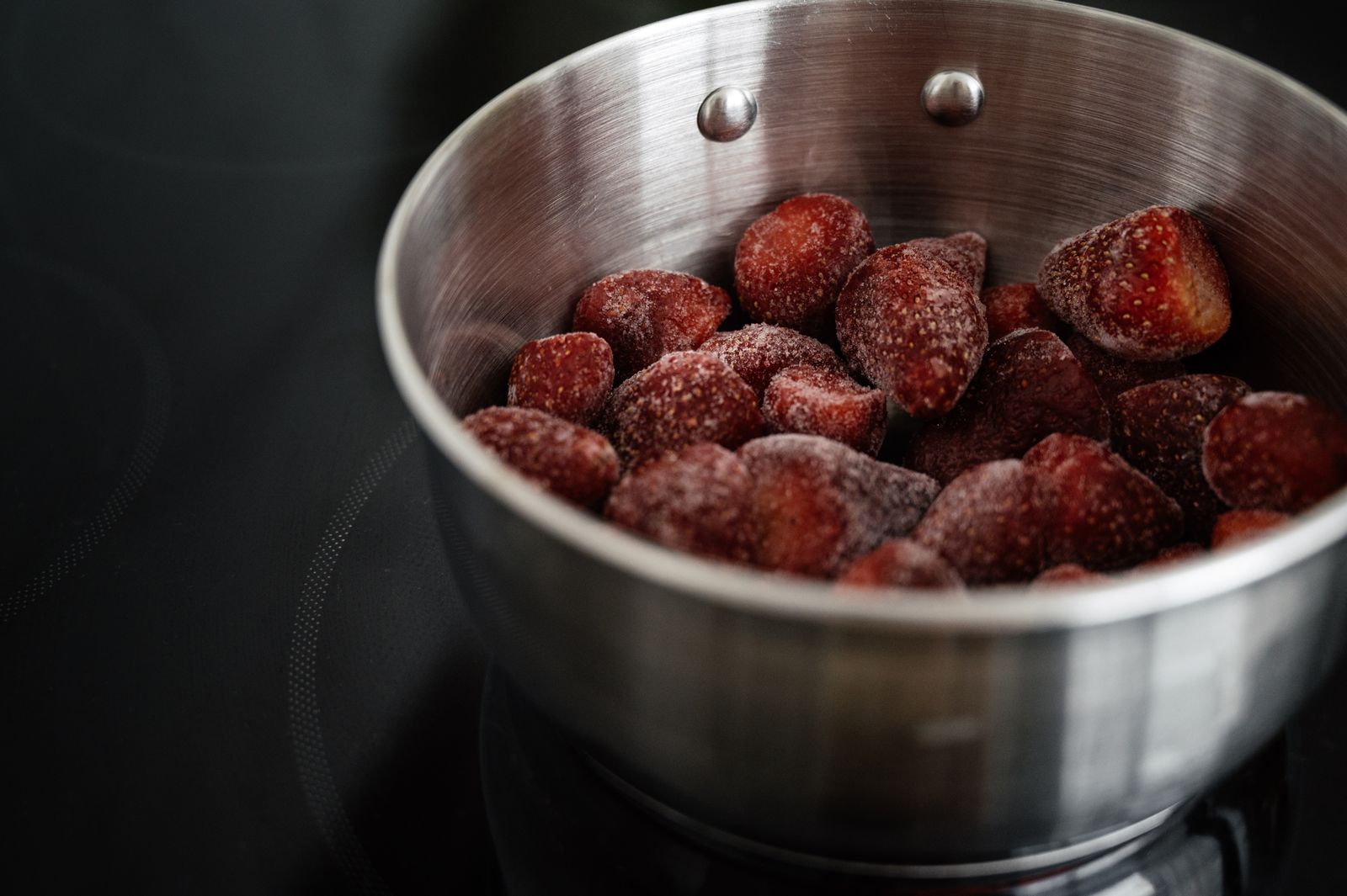 Close-up of frozen strawberries in a stainless steel bowl