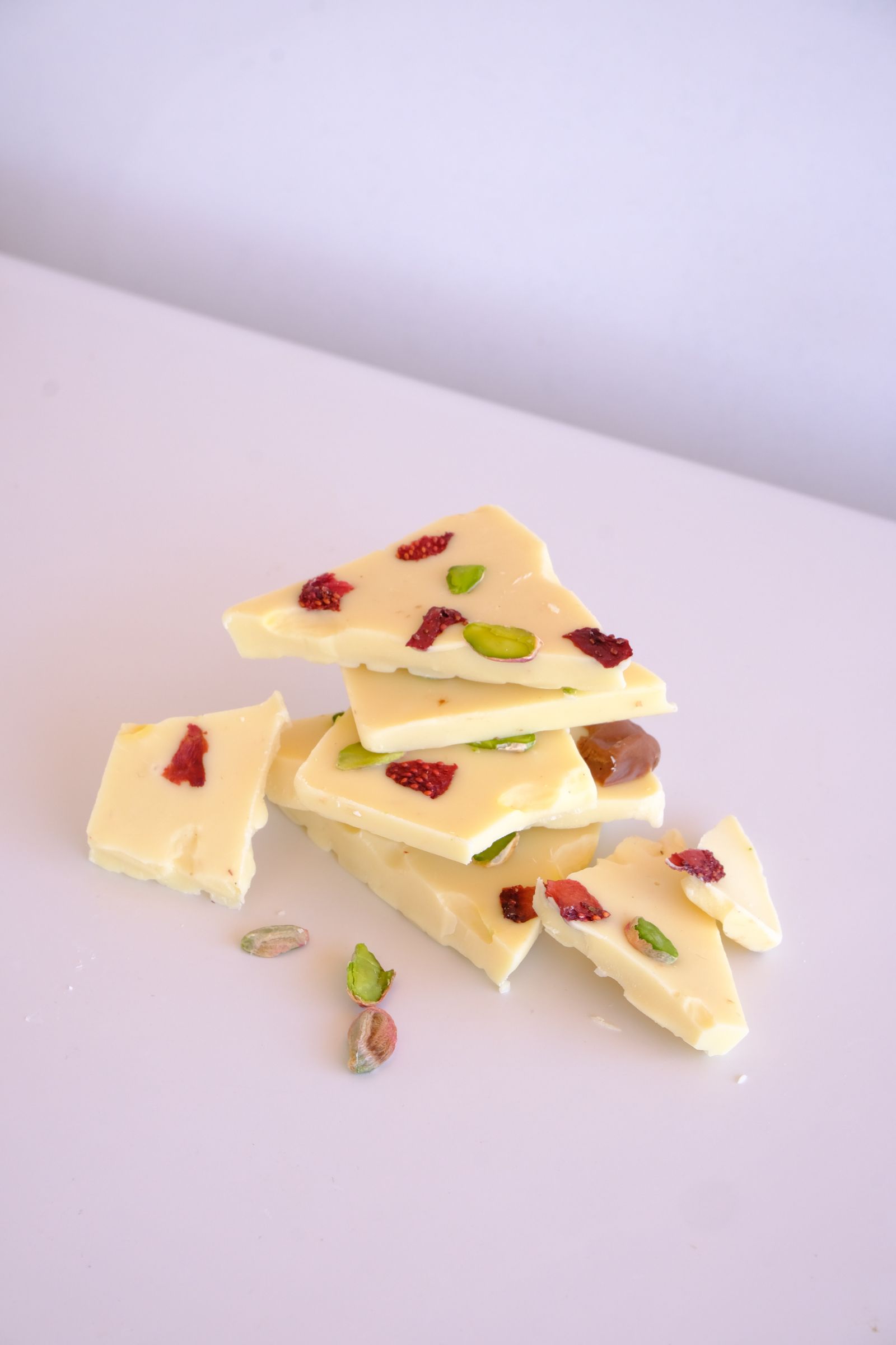 Stacked pieces of white chocolate bark with pistachios and dried fruit