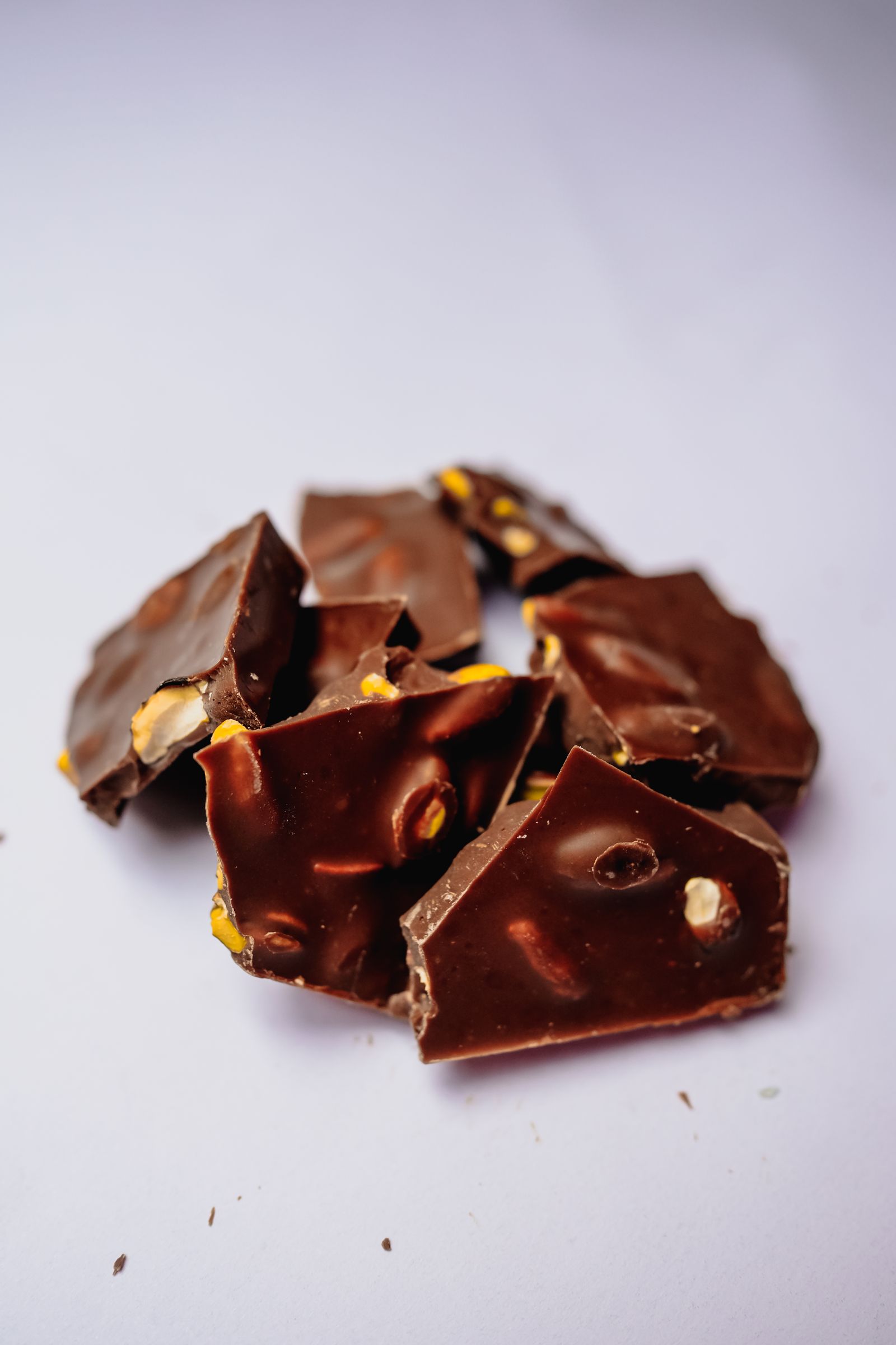 Broken pieces of chocolate bark stacked on a white surface